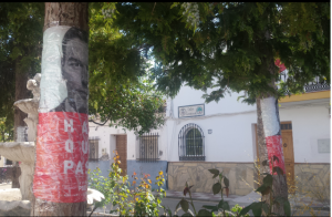 Carteles del PSOE liados a árboles y de fondo el Ayuntamiento de Játar 